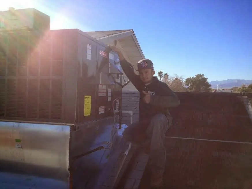 HVAC technician performing AC Tune-Up on a rooftop unit in New Fairfield